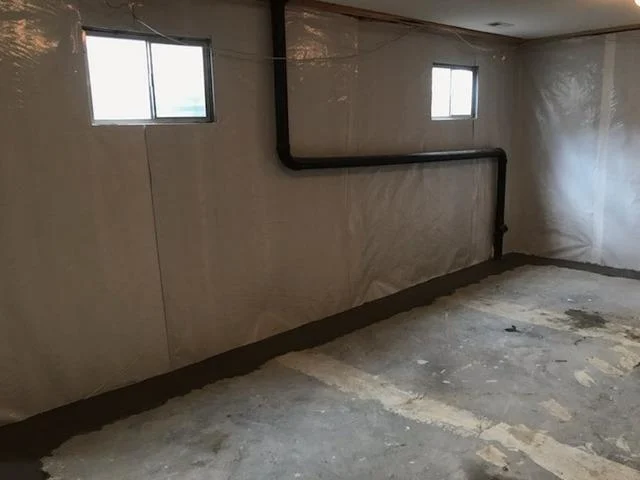 The image depicts a basement after repair, with newly repaired walls and a significantly improved condition. This 'after' shot showcases the successful remediation of previous issues, such as wall cracking and moisture damage, in a Spokane Valley, WA home. The completed repair ensures enhanced structural integrity and a dry, finished appearance for the basement space.