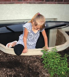 Basement egress window well cover installed to keep debris out and protect windows from water damage in Spokane