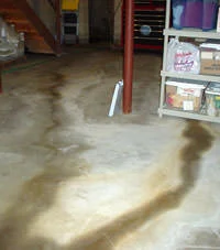 The image features cracks in a Coeur d'Alene basement floor, demonstrating the necessity for waterproofing to prevent water damage and maintain a dry, secure basement.